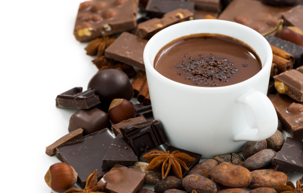 Горячий шоколад в белой чашке на столе с орехами