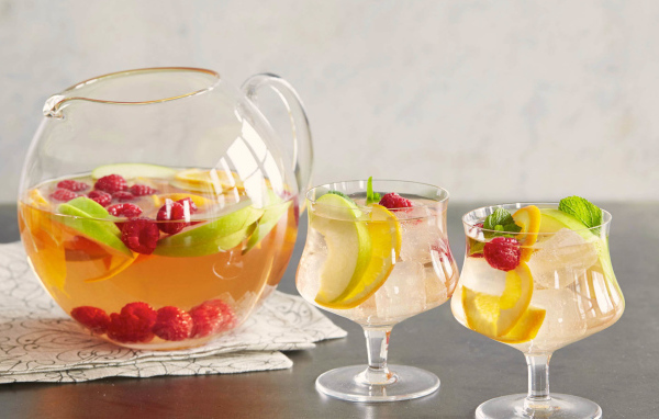 Лимонад в графине на столе с бокалами 