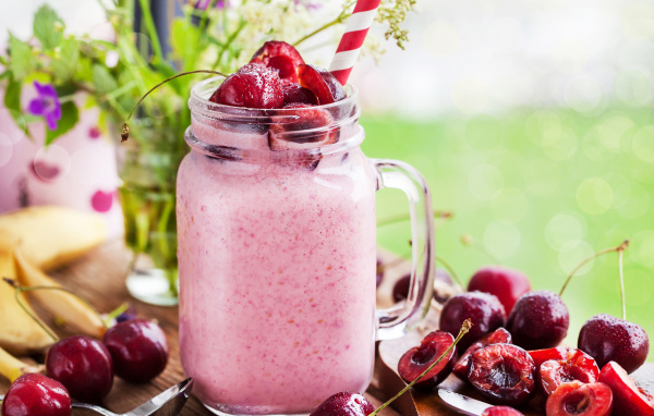 Смузи в бутылке с трубочкой и ягодами черешни 