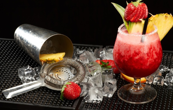 Тропический коктейль в бокале на столе со льдом