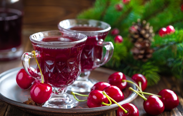 Две чашки вишневого сока со свежими вишнями на столе