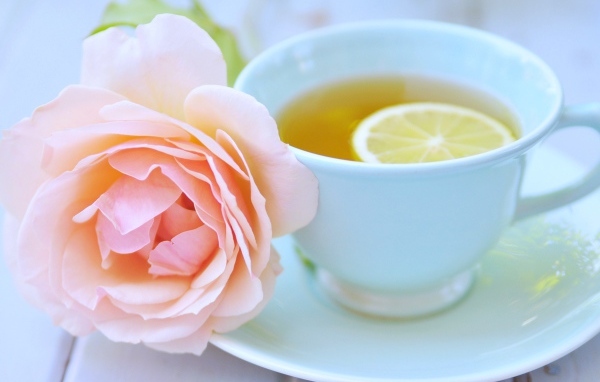 Белая чашка чая с лимоном и розовой розой