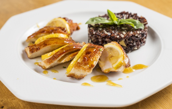 Куриный рулет на белой тарелке с рисом