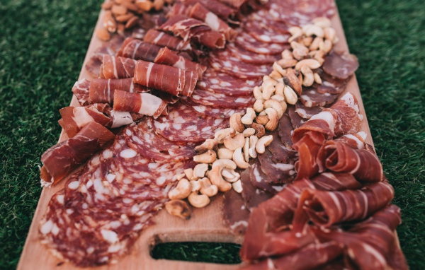Мясная нарезка с орехами на разделочной доске