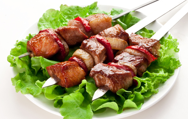 Аппетитный шашлык с листьями салата на шампурах 