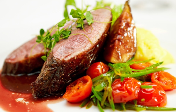 Сочное мясо с помидорами, соусом и зеленью