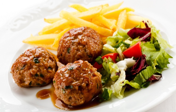 Тефтели с картофелем фри и салатом на белой тарелке 