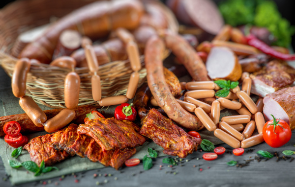 Копченые ребрышки с колбасой на столе 