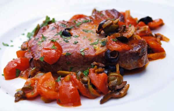 Стейк с овощами на большой белой тарелке