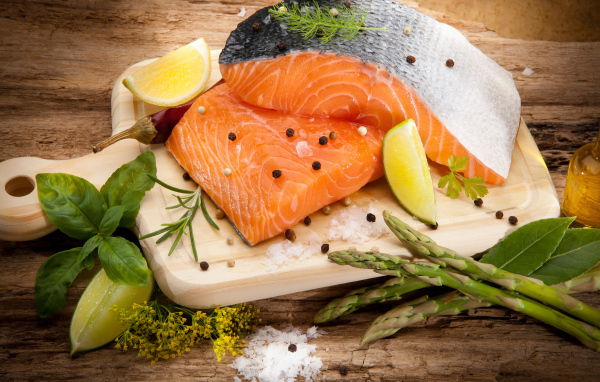 Филе красной рыбой на столе со спаржей и лаймом