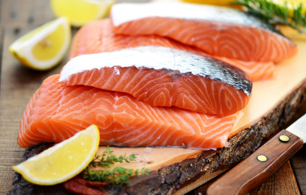 Кусочки красной рыбы с лимоном на столе