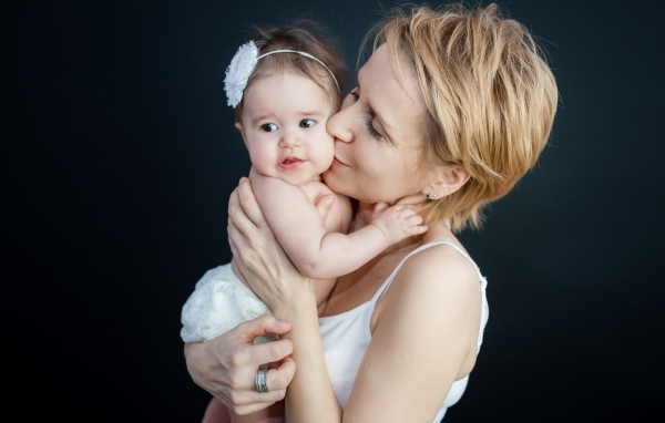 Девушка с маленькой девочкой на руках