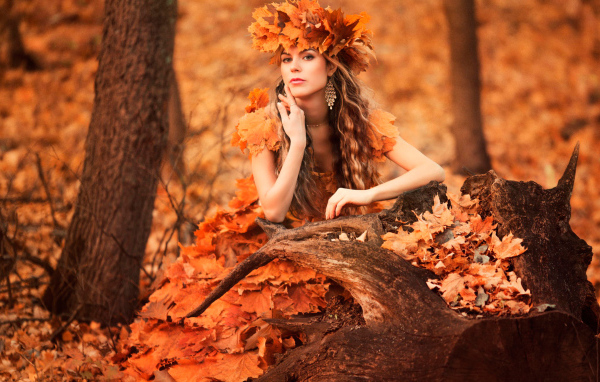 Красивая девушка осень в костюме из желтых листьев 