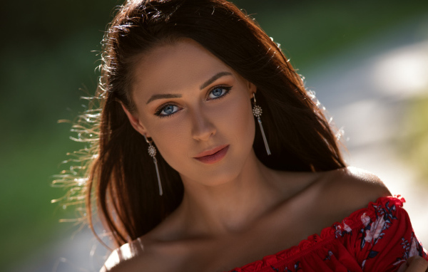 Красивая голубоглазая брюнетка с серьгами у ушах