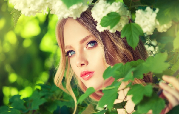 Красивая голубоглазая девушка в белых цветах 