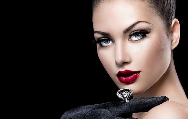 Красивая голубоглазая девушка с кольцом на пальце на черном фоне