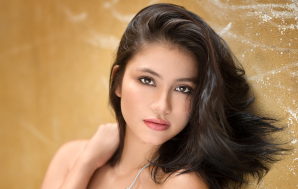 Красивая брюнетка на фоне стены 