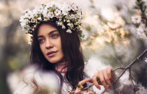 Красивая брюнетка с венком из цветов вишни на голове