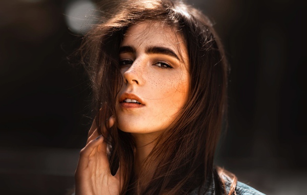 Красивая брюнетка с веснушками на лице