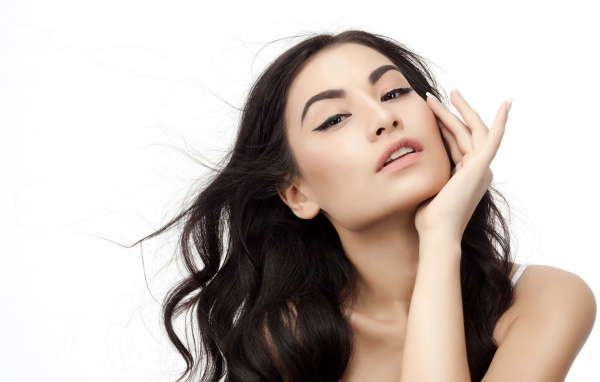 Красивая брюнетка с накрашенными глазами на белом фоне