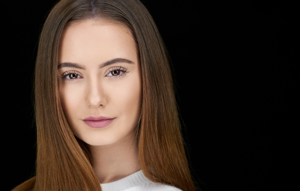 Красивая нежная шатенка на сером фоне