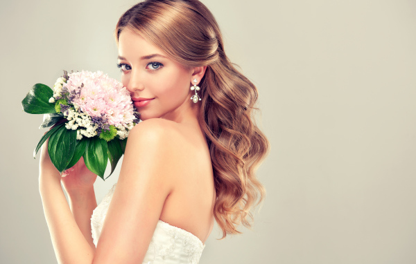 Красивая девушка невеста с букетом цветов на сером фоне