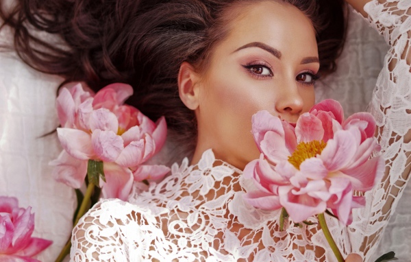 Красивая девушка в белом платье с розовыми цветами пиона 