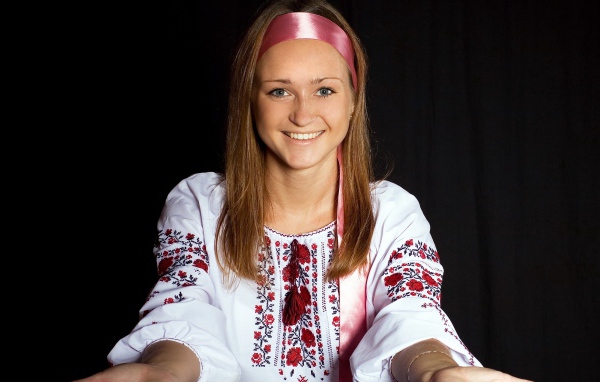 Красивая девушка в вышитой рубашке на черном фоне