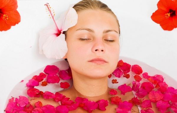 Красивая девушка в ванной с лепестками розы 