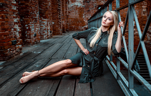 Красивая девушка сидит на деревянном полу