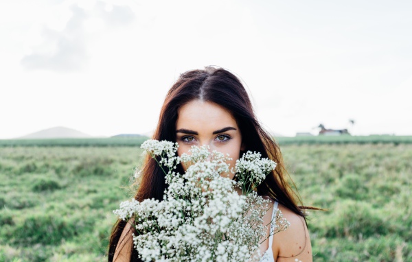 Красивая девушка с букетом полевых цветов