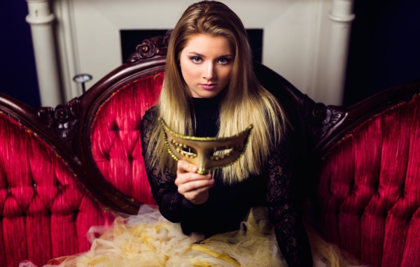 Красивая девушка с маской в руках