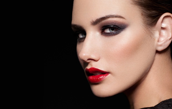Красивая девушка с яркой помадой на губах на черном фоне