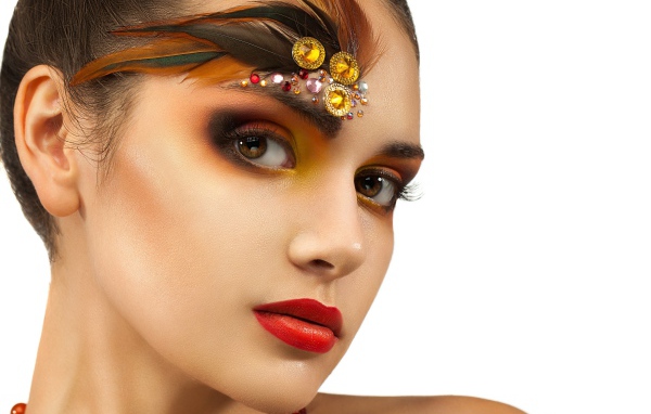 Красивая девушка с ярким макияжем и стразами на лице