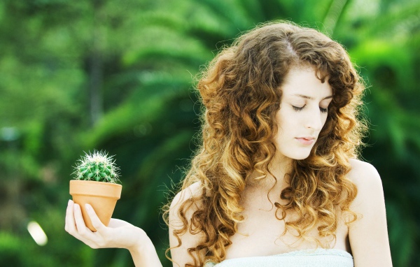 Красивая девушка с закрытыми глазами с кактусом в руке