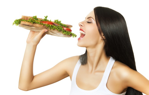 Красивая длинноволосая девушка брюнетка с большим бутербродом 