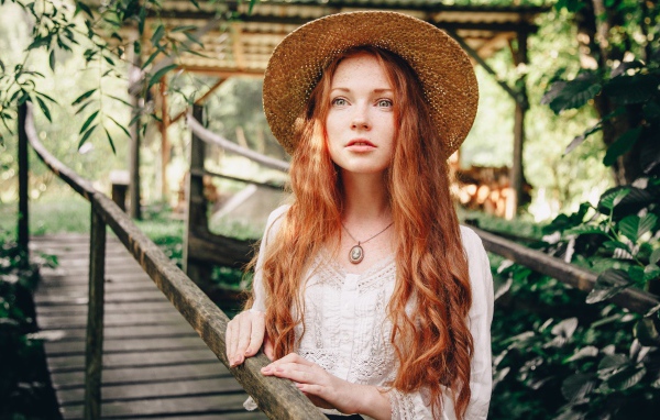 Красивая рыжеволосая девушка в соломенной шляпе