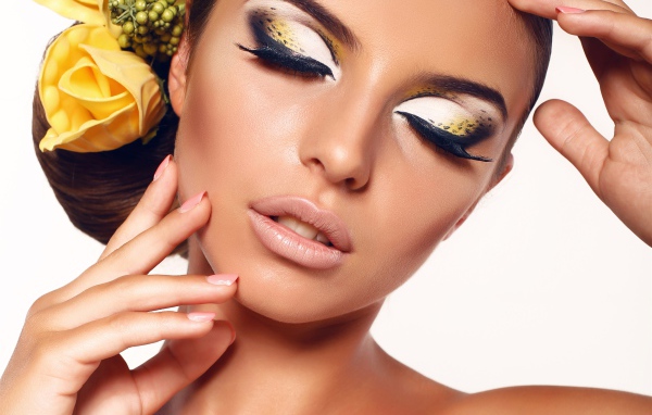 Красивая нежная девушка с ярким макияжем с цветами в волосах 