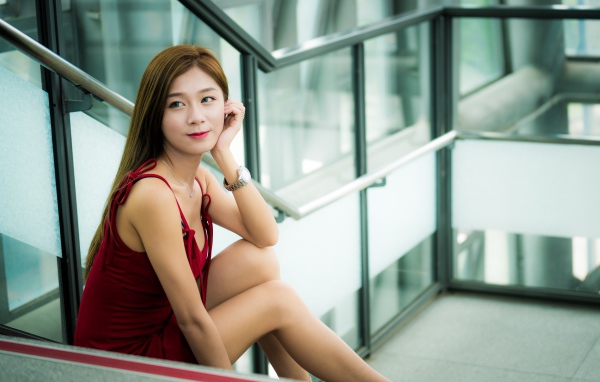 Красивая молодая девушка азиатка сидит на ступенях
