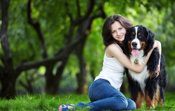 Красивая молодая девушка брюнетка обнимает собаку