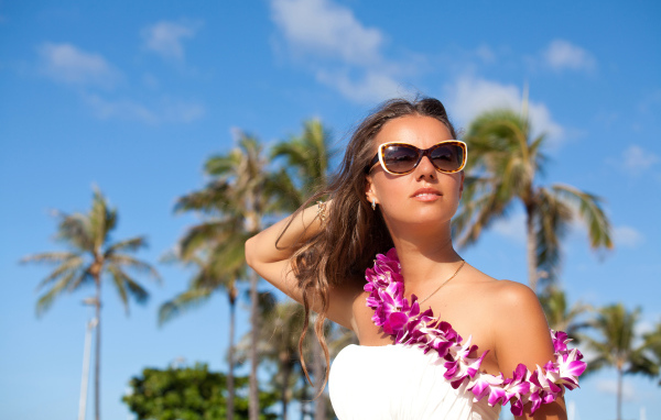 Красивая молодая девушка в солнечных очках на тропическом пляже