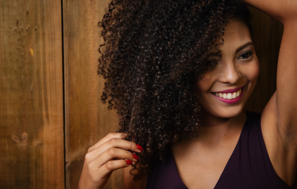 Кучерявая темнокожая девушка с красивой улыбкой 