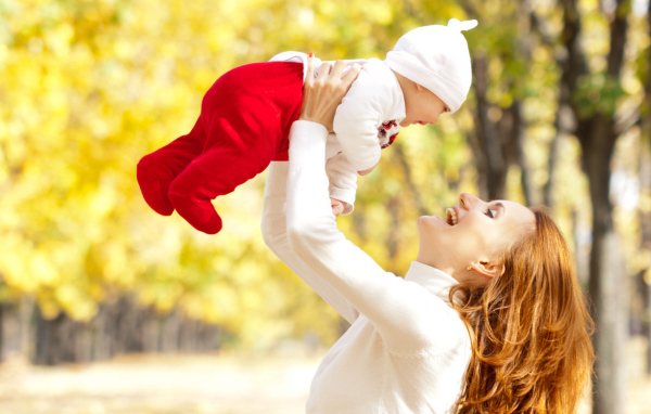 Счастливая девушка с младенцем на руках