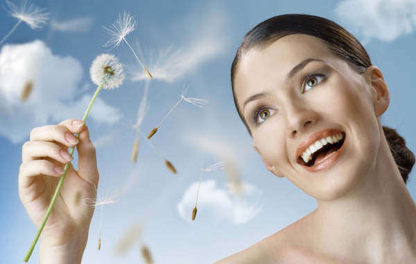 Счастливая девушка с одуванчиком в руке 