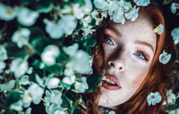 Рыжеволосая девушка с веснушками в белых цветах 