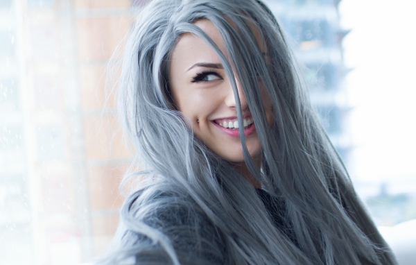 Улыбающаяся эпатажная девушка с пирсингом