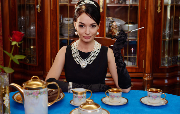 Стильная девушка в ретро стиле за столом с чаем