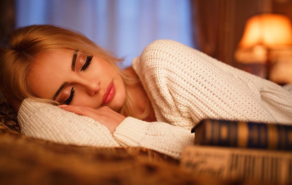 Нежная спящая блондинка в белом свитере 