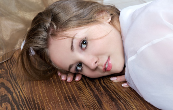 Нежная девушка шатенка лежит на полу