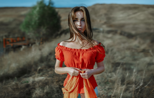 Ветер развивает волосы красивой девушке шатенке 